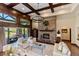 Bright and airy living room with a stone fireplace, wood beam ceilings, and large windows offering scenic views at 7767 Dante Dr, Littleton, CO 80125
