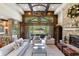 Inviting living room with a stone fireplace, wood accents, and large windows offering scenic views of the backyard at 7767 Dante Dr, Littleton, CO 80125