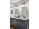 Stylish bathroom vanity with double sinks, sleek black faucets, decorative plant, and updated lighting fixtures at 6700 W 80Th Cir, Arvada, CO 80003