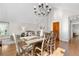 Bright dining room featuring a wooden table, chandelier, and seamless access to the living area at 6700 W 80Th Cir, Arvada, CO 80003