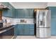 Kitchen featuring stainless steel appliances, designer backsplash, white countertops, and custom blue cabinets at 6700 W 80Th Cir, Arvada, CO 80003