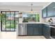 Bright kitchen featuring stainless steel appliances, custom blue cabinets, and view of the backyard at 6700 W 80Th Cir, Arvada, CO 80003