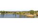 Picturesque lake view featuring a gazebo, bridge, and fountain amid natural scenery at 6700 W 80Th Cir, Arvada, CO 80003
