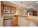 Bar with oak cabinets, a microwave, a mini fridge, a sink and an open counter area at 1825 Keota Ln, Superior, CO 80027