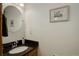A stylish half bathroom features a granite countertop and a decorative round mirror above the sink at 1825 Keota Ln, Superior, CO 80027