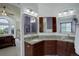 Bathroom with double vanity, granite countertops, wood cabinets and view to bedroom at 1825 Keota Ln, Superior, CO 80027