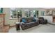 Cozy living room with a brick fireplace, comfortable seating, and bright windows overlooking the backyard at 1825 Keota Ln, Superior, CO 80027