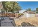 View of the fenced backyard with wood fire pit and shed at 4804 N Raleigh St, Denver, CO 80212