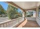 Cozy covered front porch with wood floors and white railing at 4804 N Raleigh St, Denver, CO 80212