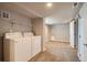 Finished laundry room in basement leading to open, carpeted area at 4804 N Raleigh St, Denver, CO 80212