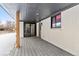 A covered back porch featuring gray deck, white brick walls, and a sliding glass door to the interior at 11241 W 60Th Ave, Arvada, CO 80004