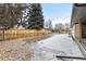 Large backyard with a wood fence, snow and leaflitter throughout the yard at 11241 W 60Th Ave, Arvada, CO 80004