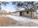 The back of the house with a covered porch and yard with some snow; includes a shed at left at 11241 W 60Th Ave, Arvada, CO 80004