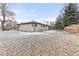 Backyard view shows mature trees, with some snow, leaflitter and partial chain link fence at 11241 W 60Th Ave, Arvada, CO 80004