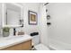 Well-lit bathroom featuring a modern vanity, framed mirror, tiled shower with plant decoration and toilet at 11241 W 60Th Ave, Arvada, CO 80004