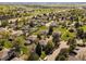 Aerial view of a neighborhood featuring green grass and mature trees surrounding homes at 3351 S Field St # 150, Lakewood, CO 80227