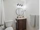 Bathroom featuring a round mirror, undermount sink, wood vanity, and toilet at 3351 S Field St # 150, Lakewood, CO 80227