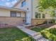 Inviting entrance with flower bed and well-manicured lawn leading to the front door at 3351 S Field St # 150, Lakewood, CO 80227