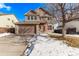 Two-story house with a brown exterior, red door, and attached garage. Snow on the ground at 672 Pitkin Way, Castle Rock, CO 80104