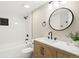 Updated bathroom with a modern vanity, round mirror, and a tiled shower/tub combo at 4274 S Salida Way # 3, Aurora, CO 80013