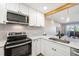 Bright kitchen with white cabinets, stainless steel appliances, and a view to the living space at 4274 S Salida Way # 3, Aurora, CO 80013