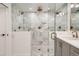 Modern bathroom with a glass enclosed shower with marble tile, dual shower heads and bronze fixtures at 366 Elm St, Denver, CO 80220