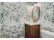 Stylish powder room with unique wallpaper, wooden vanity, and decorative mirror at 366 Elm St, Denver, CO 80220