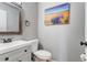 Charming half bathroom with a wood-framed mirror and a nature-themed wall painting at 1244 S Reed St # 2, Lakewood, CO 80232