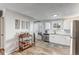 Bright kitchen with white cabinets, stainless steel appliances, and charming bar cart at 1244 S Reed St # 2, Lakewood, CO 80232
