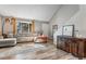 Inviting living room with vaulted ceiling, large window, modern light fixture, and stylish decor at 1244 S Reed St # 2, Lakewood, CO 80232