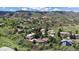 Wide aerial shot of homes nestled in a community with trees and mountains in the background at 7084 Fox Paw Trl, Littleton, CO 80125