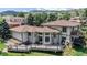 Aerial of a two-story home with a large deck and landscaped backyard featuring mature trees at 7084 Fox Paw Trl, Littleton, CO 80125