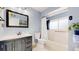 Stylish bathroom with blue walls, a vanity with a dark cabinet, a mirror, and a bathtub with a shower at 7084 Fox Paw Trl, Littleton, CO 80125