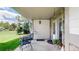 Cozy front porch with seating, a stone accent wall, and a view of the landscaped yard at 7084 Fox Paw Trl, Littleton, CO 80125