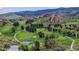 Panoramic view of the golf course with the impressive red rock formations in the background and a tranquil pond in the foreground at 7084 Fox Paw Trl, Littleton, CO 80125