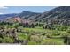 Scenic golf course view featuring mature trees and rolling green hills with the red rock formations in the background at 7084 Fox Paw Trl, Littleton, CO 80125