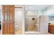 Modern shower with sleek glass doors, natural stone flooring, and built-in shelving at 7084 Fox Paw Trl, Littleton, CO 80125