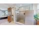 Elegant shower with glass doors, pebble flooring, and tiled walls, located off the main bedroom at 7084 Fox Paw Trl, Littleton, CO 80125