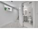 White basement with gray carpet leads to a bathroom with white patterned tile and gray vanity at 1939 S Sherman St, Denver, CO 80210