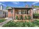 Charming brick home featuring a well-manicured lawn, tidy front yard with flowerbed, and a covered front porch entrance at 1939 S Sherman St, Denver, CO 80210