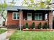 Charming brick home with a cozy front porch, freshly manicured lawn, and beautiful curb appeal at 1939 S Sherman St, Denver, CO 80210