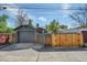 View of the single-car detached garage with a driveway and a wooden fence in a backyard setting at 1939 S Sherman St, Denver, CO 80210