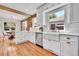 Stylish kitchen with white cabinets, hardwood floors, a farmhouse sink, and a view to the dining area for easy entertaining at 1939 S Sherman St, Denver, CO 80210