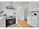 Well-lit kitchen with stainless steel appliances, white cabinets, hardwood floors, and modern fixtures for a clean design at 1939 S Sherman St, Denver, CO 80210