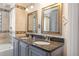 Bathroom boasts double vanity with granite counters, framed mirrors, and stylish fixtures at 6895 E 74Th Ave, Commerce City, CO 80022
