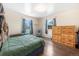 Bedroom with wood floors, bright window and wooden dresser at 6895 E 74Th Ave, Commerce City, CO 80022