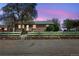Charming single-story brick home with a white picket fence and stone retaining wall at 6895 E 74Th Ave, Commerce City, CO 80022
