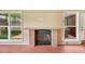 Cozy fireplace with stone mantel, flanked by windows offering backyard views at 6895 E 74Th Ave, Commerce City, CO 80022