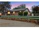 Brick home with a white picket fence and stone wall, set in a well-kept front yard at dusk at 6895 E 74Th Ave, Commerce City, CO 80022