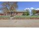 Charming brick home with a white picket fence and stone wall in a well-kept front yard at 6895 E 74Th Ave, Commerce City, CO 80022